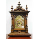 A late 19th century Continental walnut cased mantel clock, of architectural form, having a brass