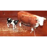 A Beswick model of a Hereford cow No. 1360; and another of a Friesian calf, model No. 1249C (2)