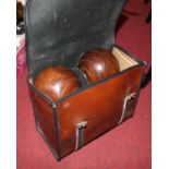 A set of four lignum vitae bowling bowls in a leather case