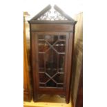An early 20th century mahogany corner cabinet, enclosed by an astragal glazed door, h.105cm