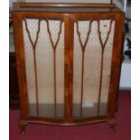 A 1930s walnut display cabinet of serpentine form on squat cabriole supports, width 90cm