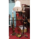 An early 20th century wrought iron standard lamp; together with a carved giltwood standard lamp (