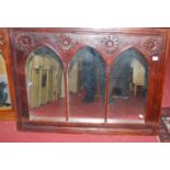 A pair of reproduction hardwood and Gothic influence wall mirrors, each with rosette carving, 75 x