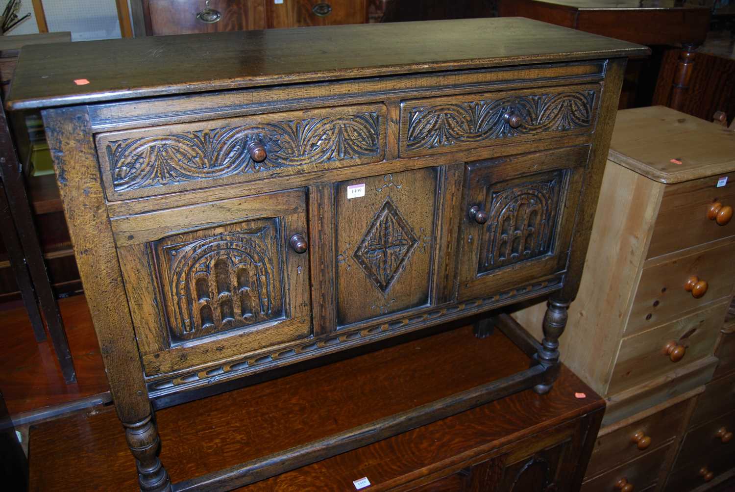 A small joined and relief carved oak dresser base having twin drawers and cupboard doors on turned - Image 2 of 5