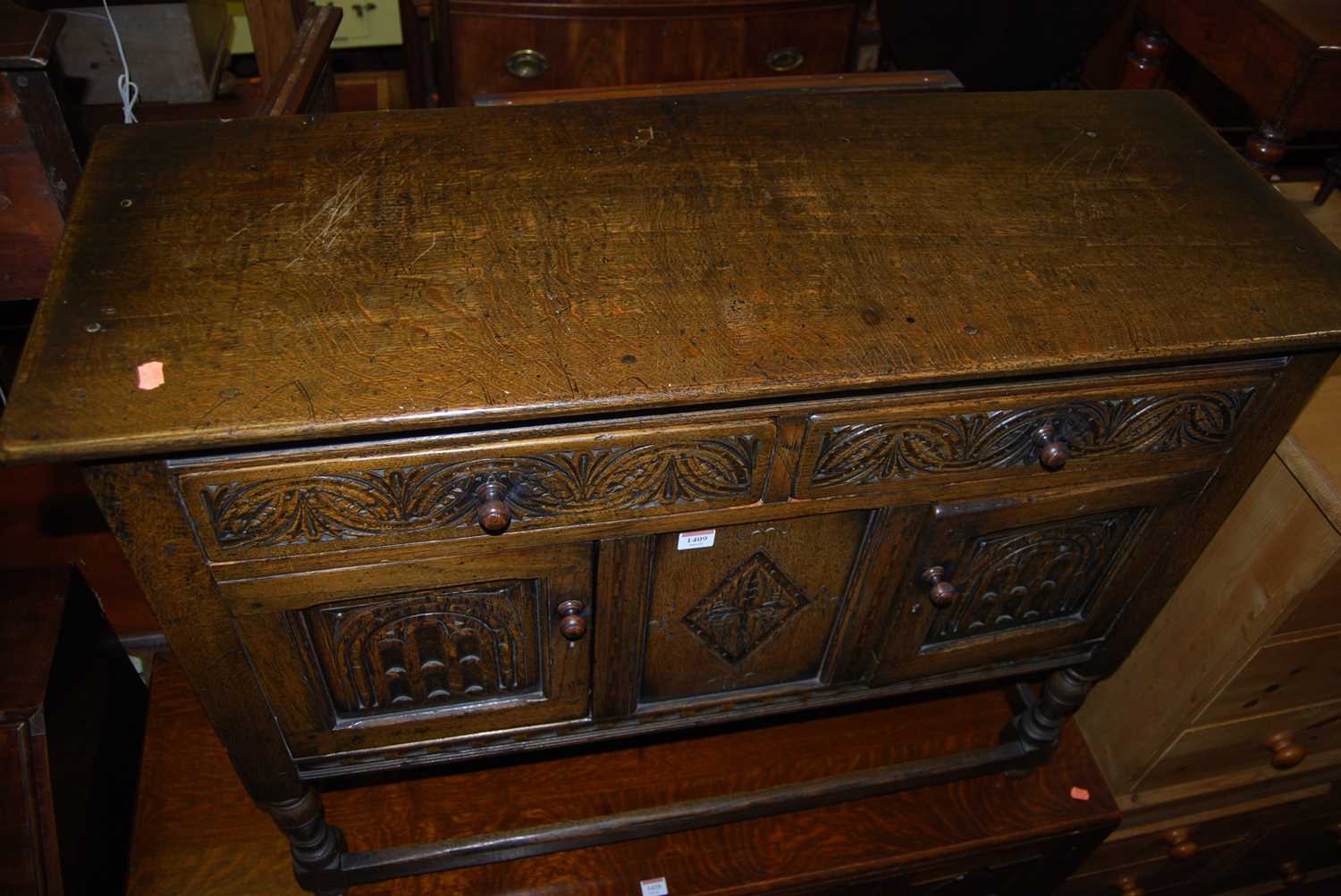 A small joined and relief carved oak dresser base having twin drawers and cupboard doors on turned - Image 5 of 5