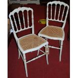 A pair of Victorian cane seated ivory painted bedroom chairs