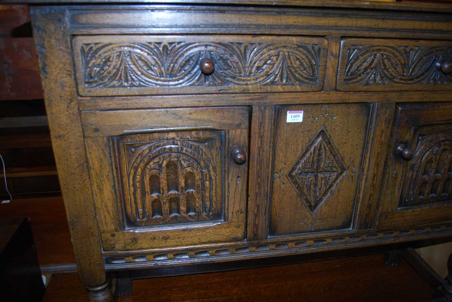 A small joined and relief carved oak dresser base having twin drawers and cupboard doors on turned - Image 3 of 5