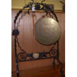 An early 20th century wrought iron and brass dinner gong, with beater, h.85cm