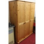 A modern pine triple wardrobe, w.127cm