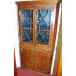 A figured walnut freestanding four door corner cupboard, in the Georgian taste, height 194cm