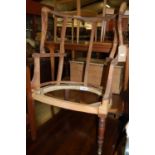 An early 19th century mahogany framed barrelback armchair (lacking upholstery and webbing), raised