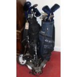 Two sets of golf clubs and bags, each with trolley