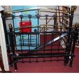 A Victorian black painted wrought iron and brass double bedstead with rails