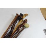 Assorted walking canes to include; root carved example, hardwood example with white metal inlays,