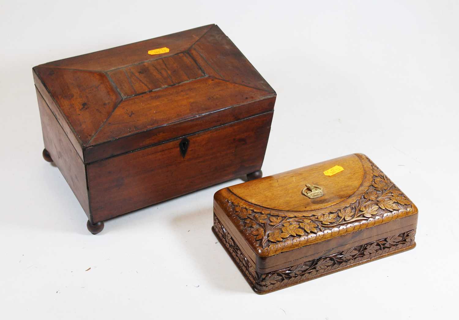 A Regency mahogany tea caddy, of sarcophagus form with kite shaped escutcheons standing on four ball