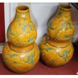 A pair of Chinese double gourd floor vases, decorated with bats in green, on a yellow ground, each