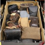 A box containing a collection of various 20th century cameras and binoculars, to include a Halma