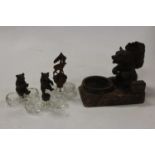 An early 20th century Black Forest style carved softwood ashtray surmounted by a bear with a