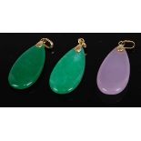 A pair of polished green jade elliptical pendants, with 14ct gold mounts, 3cm; together with a