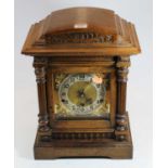 A circa 1900 Continental walnut cased mantel clock, having a silvered dial with Arabic numerals,