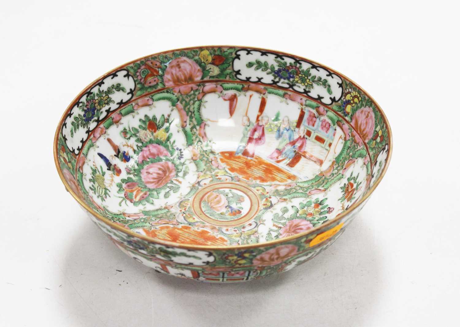 A Chinese Canton Famille Rose bowl typically decorated with various figures within a landscape