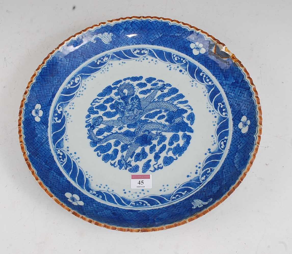 A large Chinese stoneware blue & white charger the centre glazed with a dragon amidst clouds