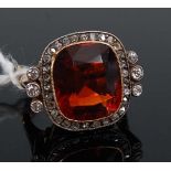 An 18ct gold orange quartz and diamond set dress ring, circa 1920s, the oval cut quartz measuring