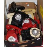 A box of various colour mid-20th century bakelite telephones