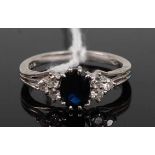 A platinum, sapphire and diamond ring, arranged as an eight-claw set oval cut sapphire flanked to