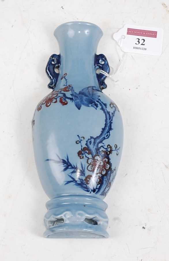 A Chinese export wall pocket in the form of a vase on blue ground decorated with birds amidst