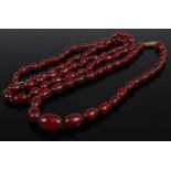 A beaded and knotted cherry amber long necklace, 66cm; together with a graduated example, 40cm,