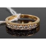 An 18ct gold diamond half eternity ring, arranged as seven channel set brilliants, total diamond
