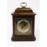 A walnut cased mantel clock, in the 18th century style, having a silvered dial with Roman