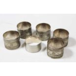 Five various Middle Eastern white metal napkin rings, each with engraved banded decoration, together