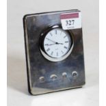 A modern silver clad easel mantel clock, having a circular dial with quartz movement, h.11cm