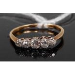 An 18ct gold diamond ring, arranged as five graduated round cuts in a line setting, total diamond