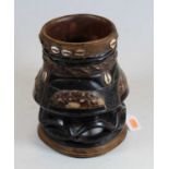 A carved softwood and ebonised tribal style vessel, with applied shell decoration, h.25cm