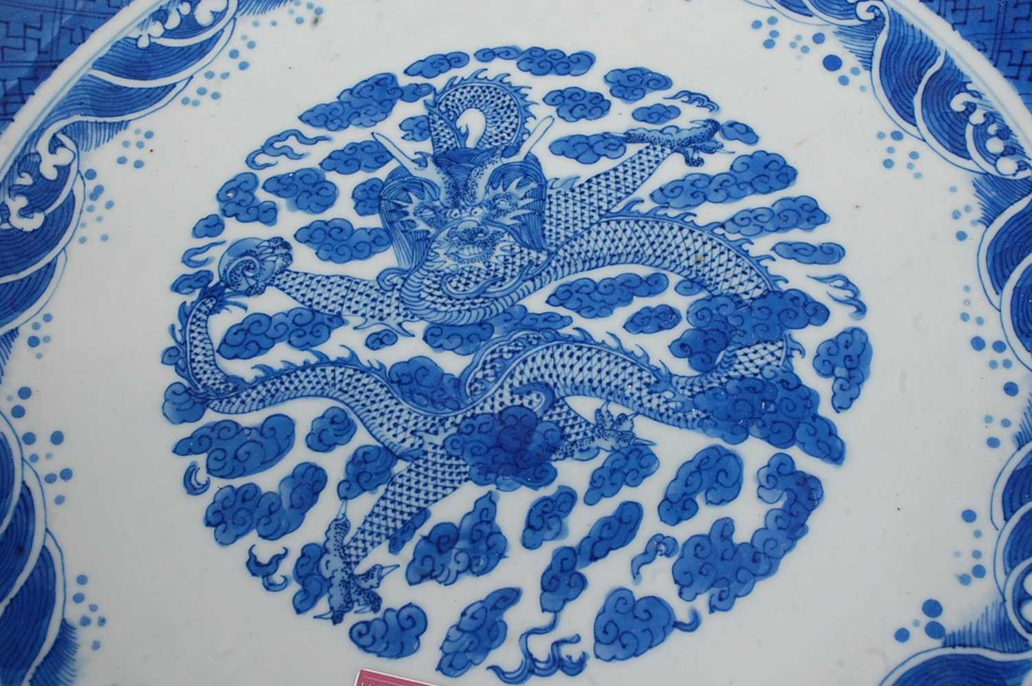 A large Chinese stoneware blue & white charger the centre glazed with a dragon amidst clouds - Image 4 of 9