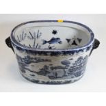 A blue and white stoneware footbath, decorated with Chinese landscapes, 46cm wide