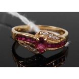 A contemporary 14ct gold, ruby and diamond set dress ring, arranged as a centre four-claw set oval