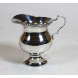 A George V silver cream jug, having beaded rim and C-scroll handle, maker S. Blanckensee & Sons,