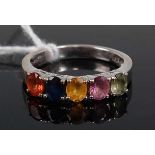An 18ct white gold and multi-coloured sapphire set dress ring, arranged as five four-claw set oval