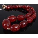 A graduated cherry amber barrel bead necklace, with yellow metal clasp, 46g, length 42cm, the