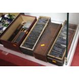 Four boxes containing a collection of various magic lantern slides to include several