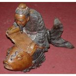 A large bronze figure, modelled as a Japanese scholar seated on a koi carp, holding a scroll,