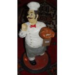 A painted fibreglass model of a standing pastry chef, h.61cm