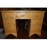 A modern pine kneehole dressing table, having arrangement of seven drawers, w.112cm