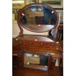 An early 20th century mahogany oval bevelled swing mirror back dressing table mirror, having twin