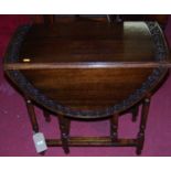 An early 20th century floral relief carved oak drop leaf occasional table, the oval fall leaves with