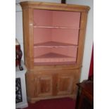 A 19th century pine freestanding corner cupboard of good size, the painted open upper section with